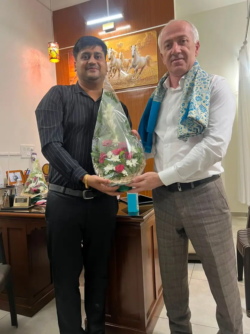 A Doctors Build International representative presenting a bouquet to the Dean of North Caucasian State Academy during a partnership visit