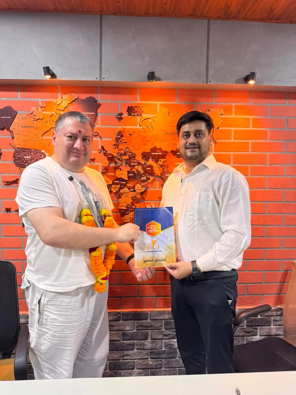 Two representatives holding a partnership plaque between them